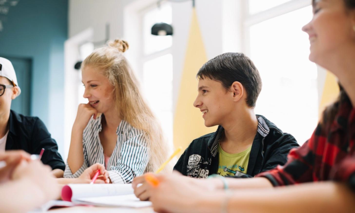 Small group financial modeling session with laptops and notebooks